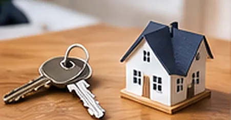 A set of house keys resting on a table near closing paperwork